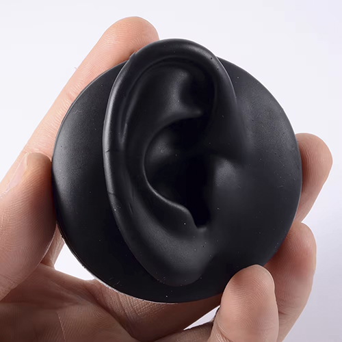 Photo d'une fausse oreille en silicone noir pour simuler le port de bijoux à l'oreille