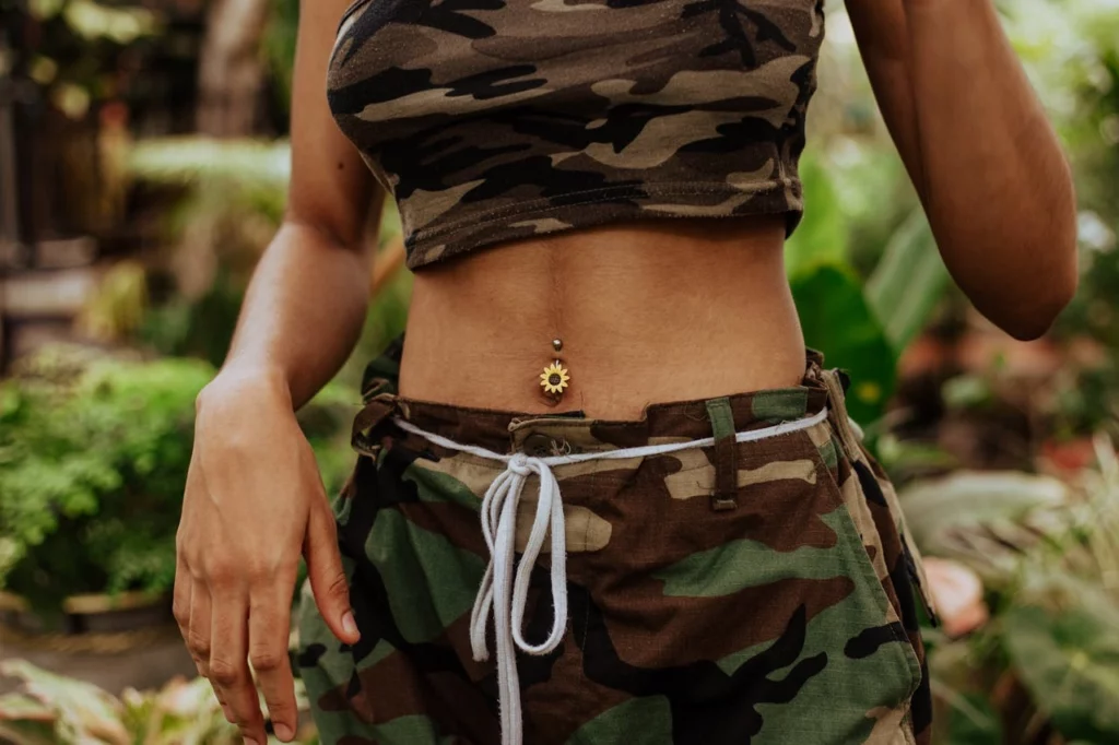 le ventre d'une femme avec une piercing au nombril en forme de fleur
