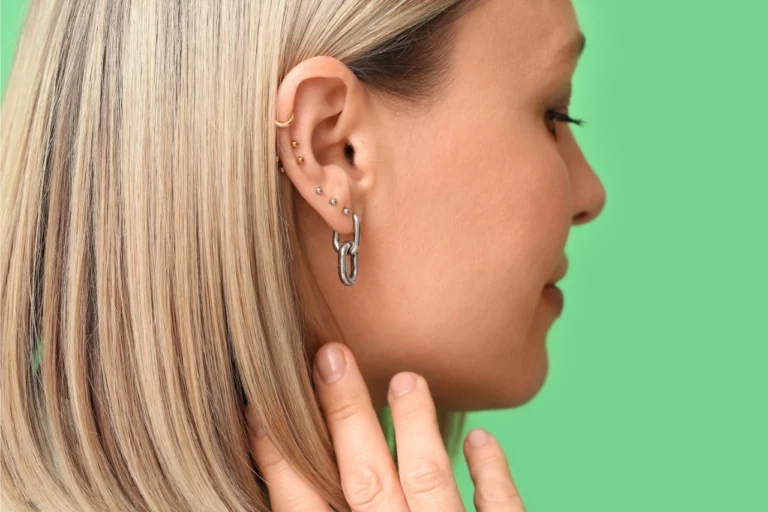 femme de profil montrant son oreille sur laquelle on découvre un piercing titane helix