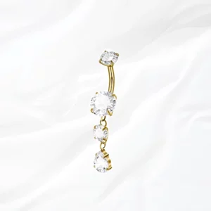 Piercing de nombril banane en titane doré "la cascade précieuse" avec pendentif cascade de trois zircons clairs et pierre en goutte