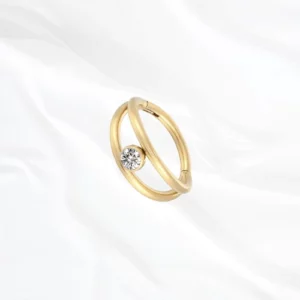 Anneau segment clipsable en titane doré Le Clairvoyant, zircon serti clos suspendu dans l’intervalle entre deux joncs lisses