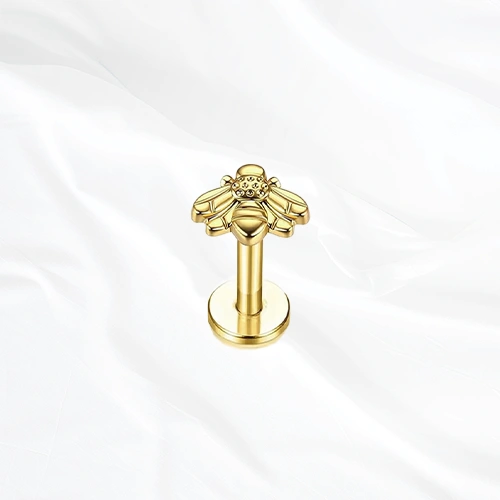 Labret en titane doré L’Abeille, abeille entièrement sculptée dans le titane, corps strié et ailes lisses déployées