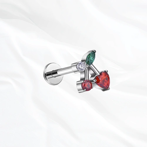 Labret en titane argenté La Cerise, deux cerises rouges sur une même branche, l’une taillée en cœur et l’autre ronde, sous une feuille verte