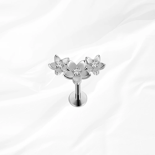 Labret push-in en titane argenté La Compo Florale, trois fleurs assemblées en grappe diagonale avec un zircon au cœur de chacune