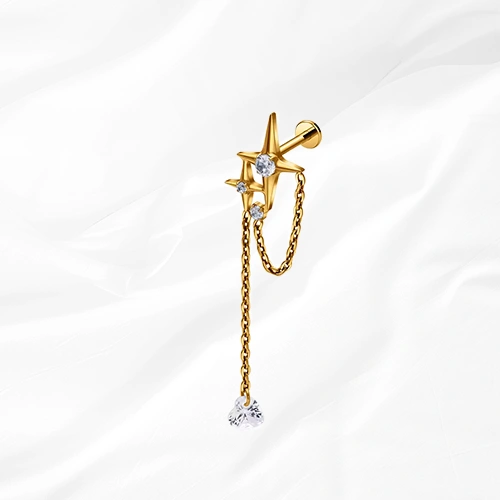 Labret en titane doré La Grande Constellation, étoile sertie et chaînette doublée jusqu’à un zircon poire suspendu