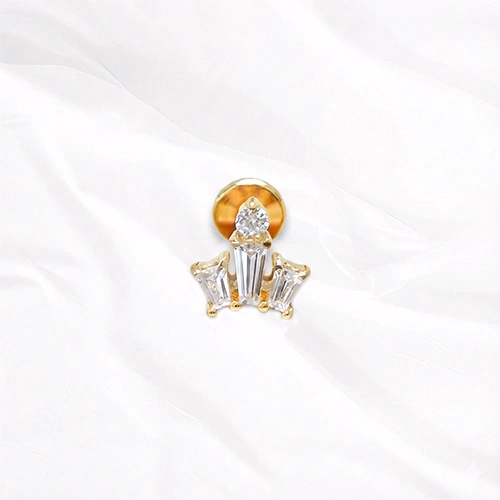 Labret en titane doré La Petite Couronne, trois zircons baguette dressés en créneaux coiffés d’un zircon poire