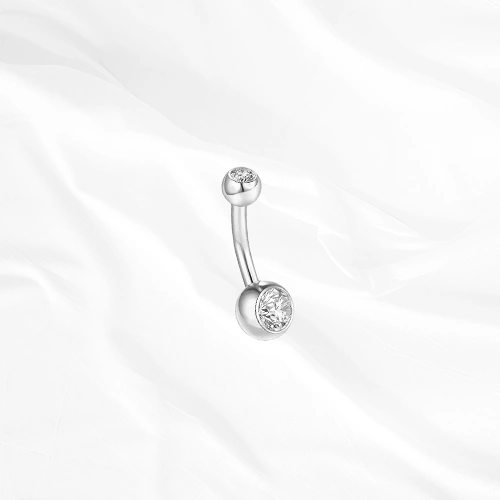 Piercing de nombril banane en titane argenté Le Nombriliste, un zircon serti clos à chaque extrémité dans une monture affleurante