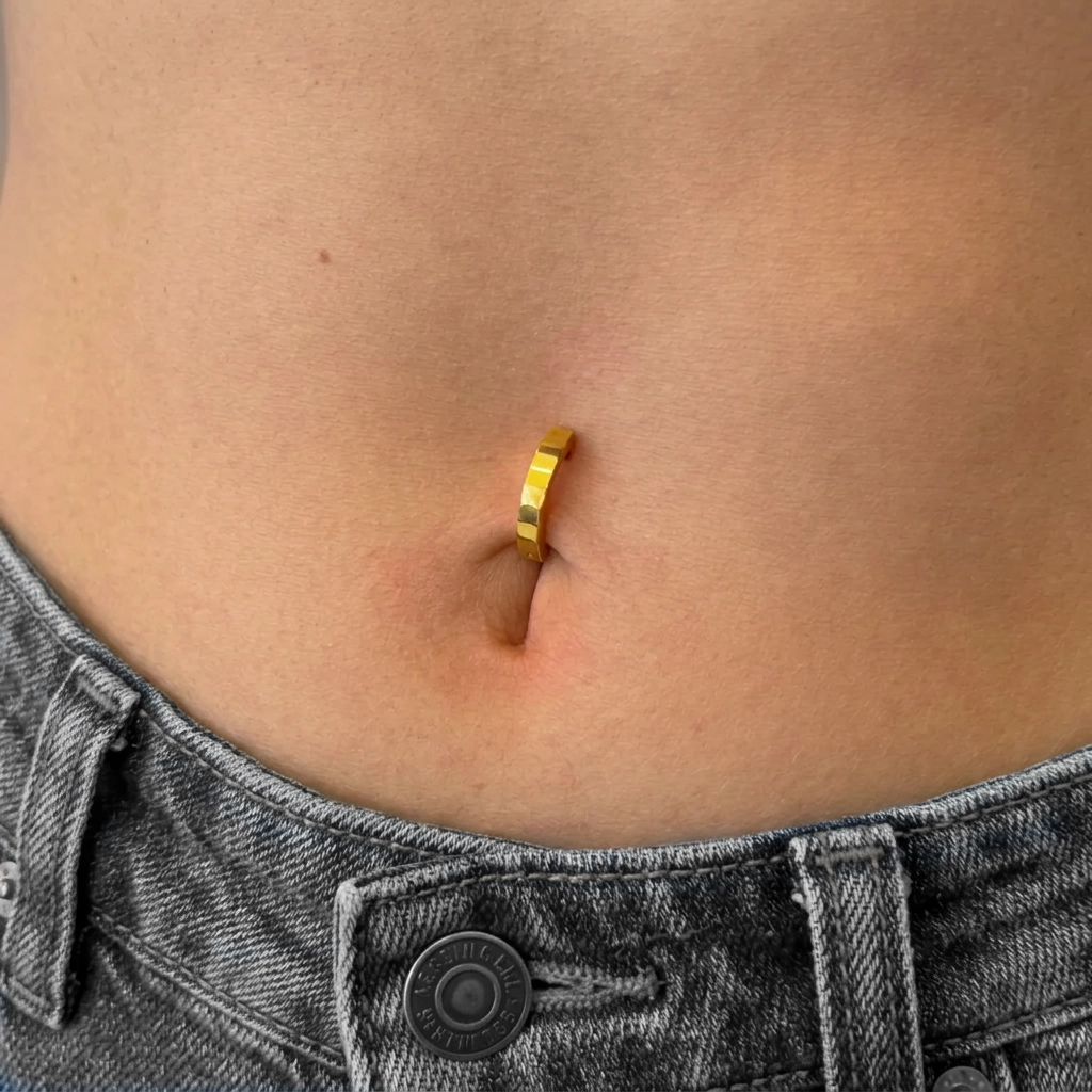 Piercing Le Clip en titane doré porté au nombril