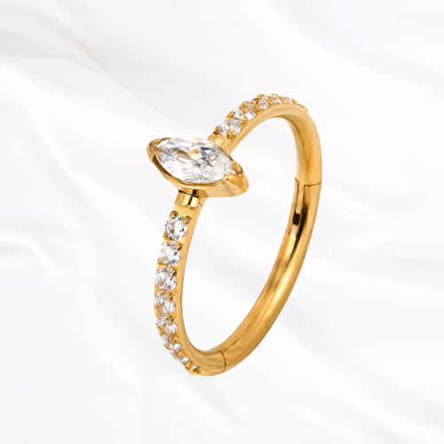 Anneau segment clipsable en titane doré L’Atout, ligne de petits zircons s’achevant par une marquise nettement plus grande posée en tête