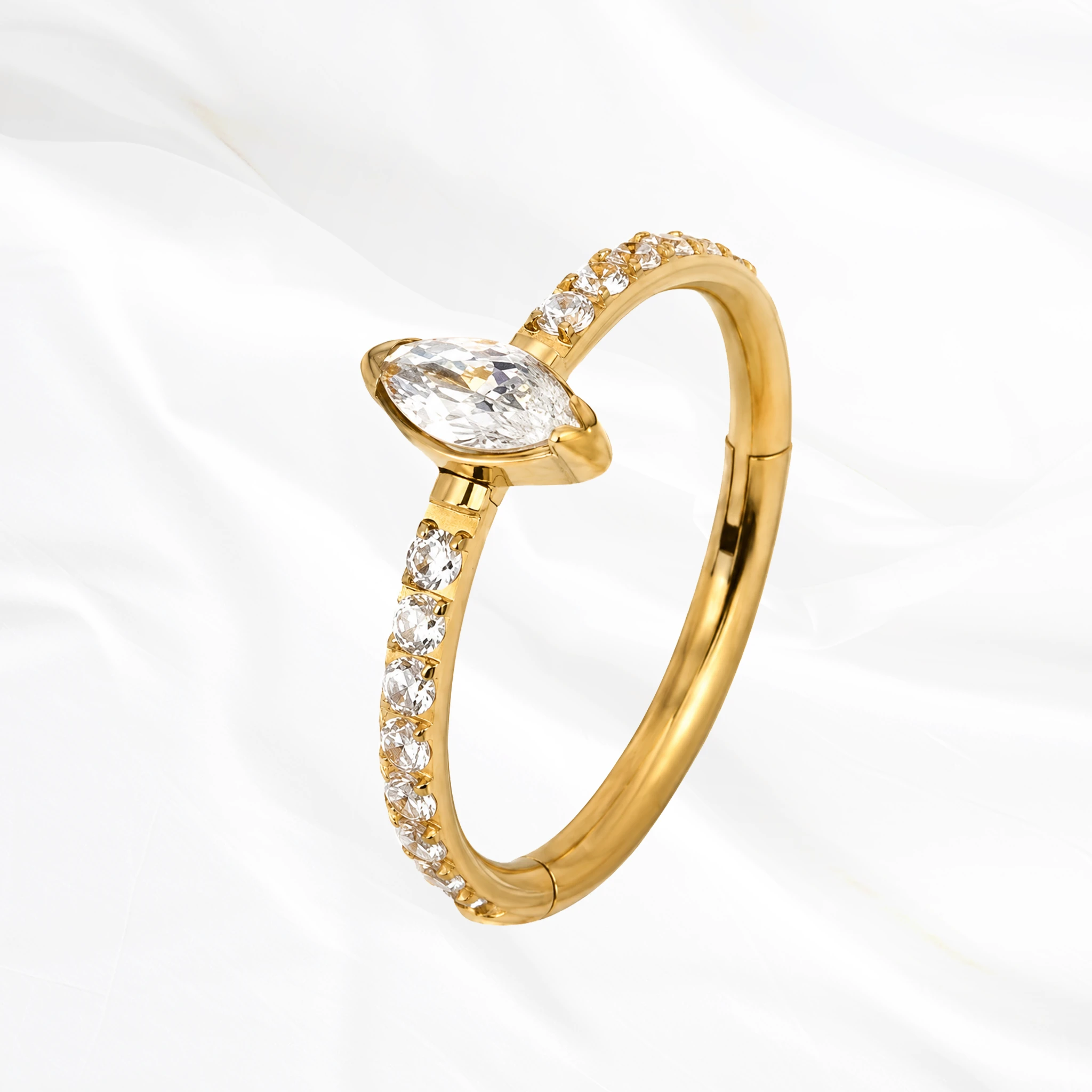 Anneau segment clipsable en titane doré L’Atout, ligne de petits zircons s’achevant par une marquise nettement plus grande posée en tête