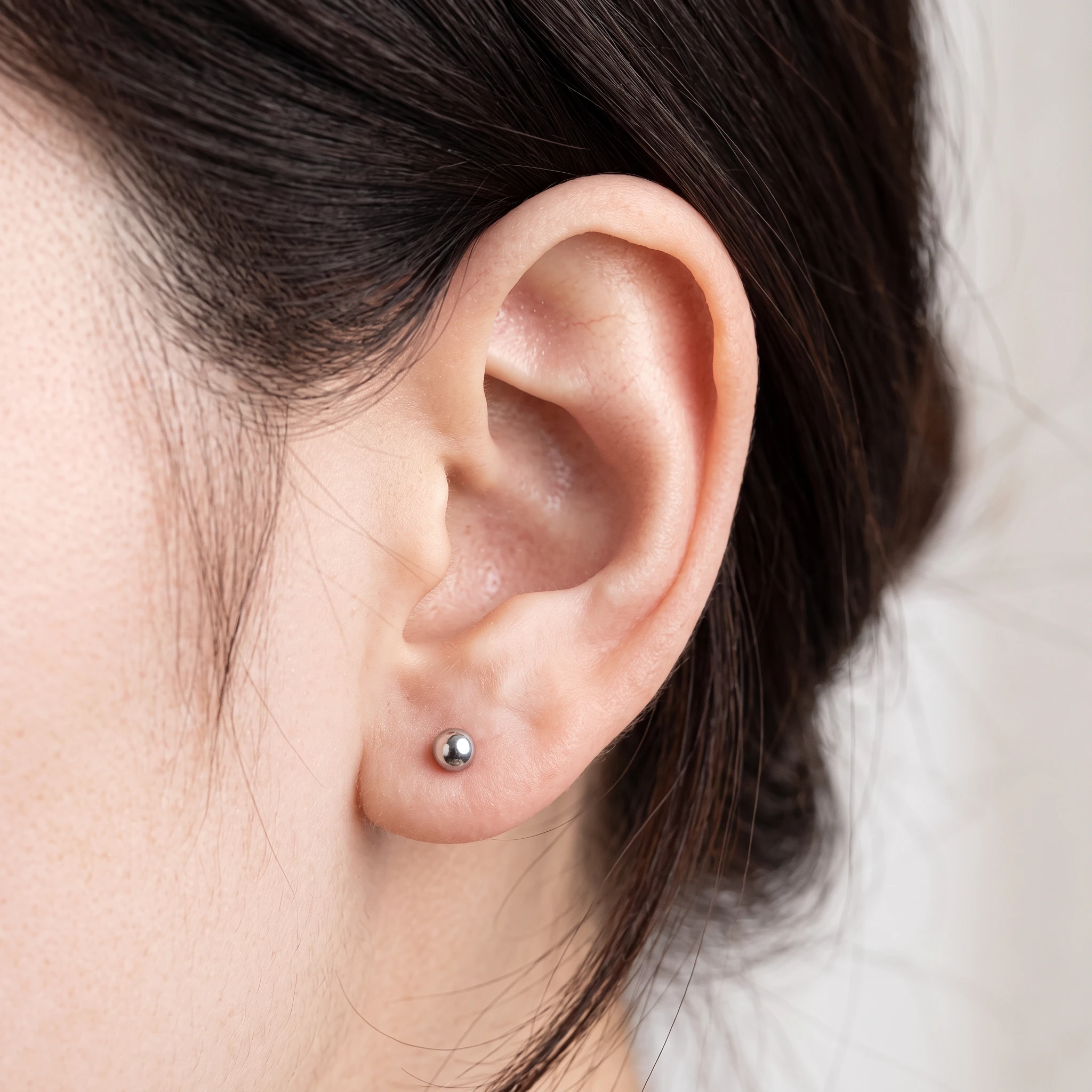 Piercing Boule Simple en titane argenté porté à l'oreille
