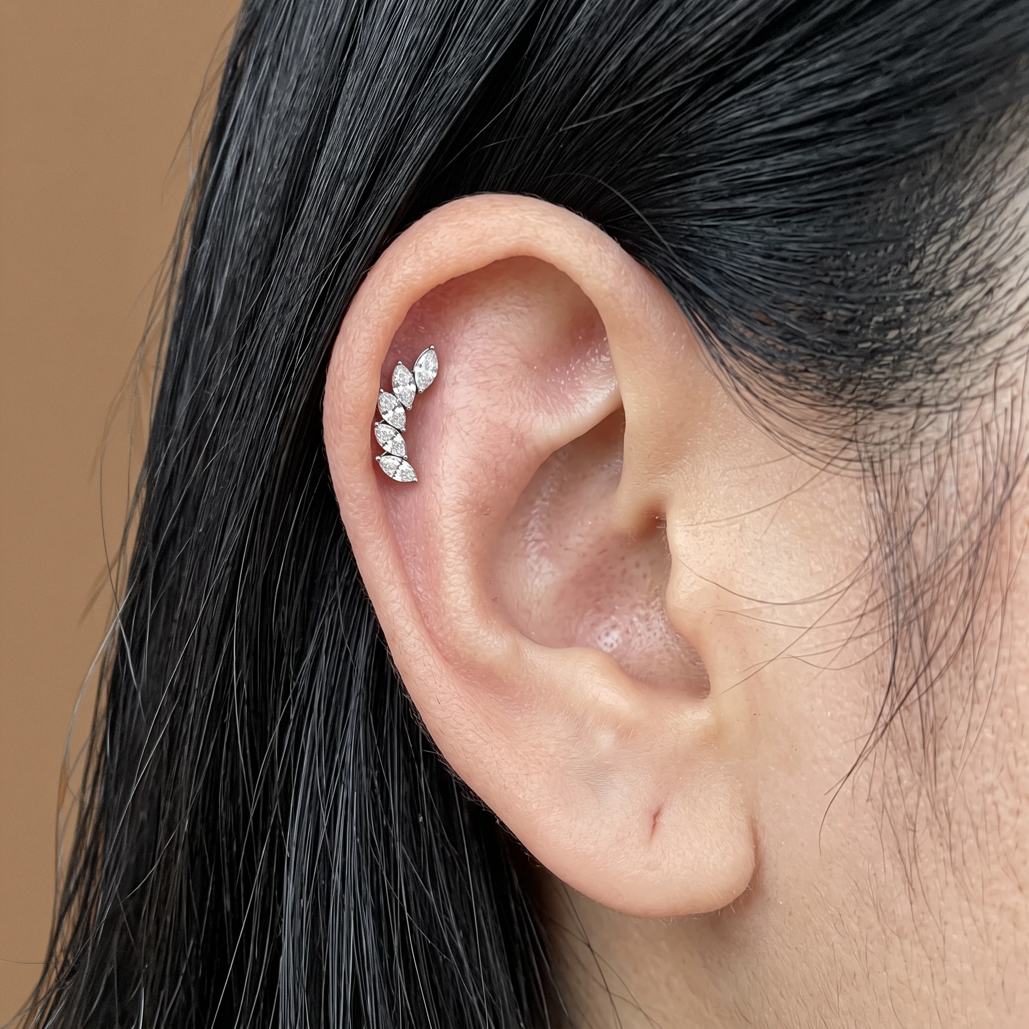Piercing La Courbe Royale en titane argenté porté à l'oreille