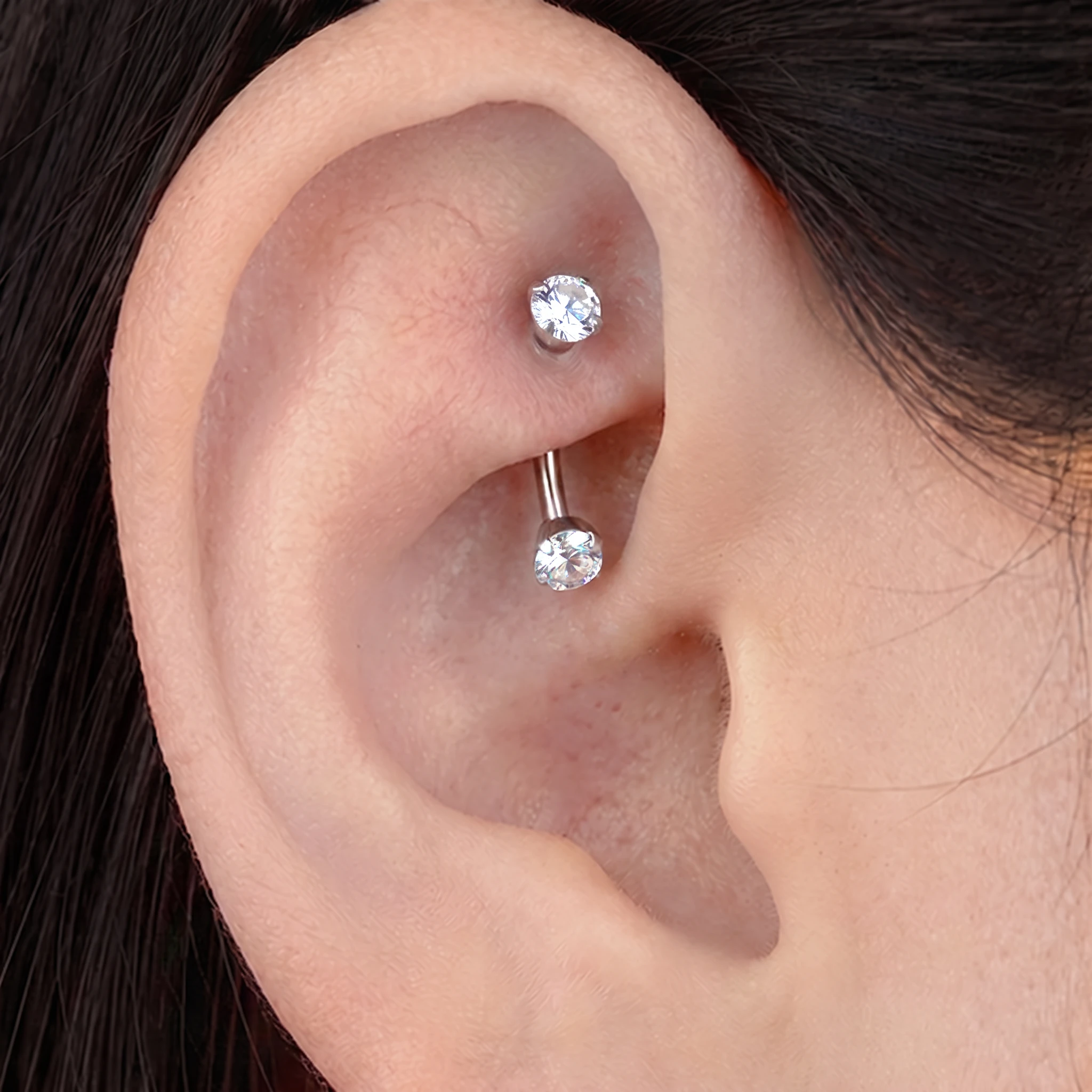 Piercing La Courbe Sertie en titane argenté porté à l'oreille