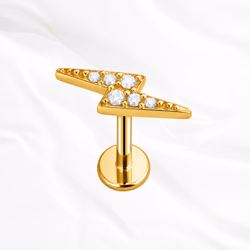 Labret en titane doré L’Éclair, éclair en deux branches brisées pavé de petits zircons suivant la ligne en zigzag