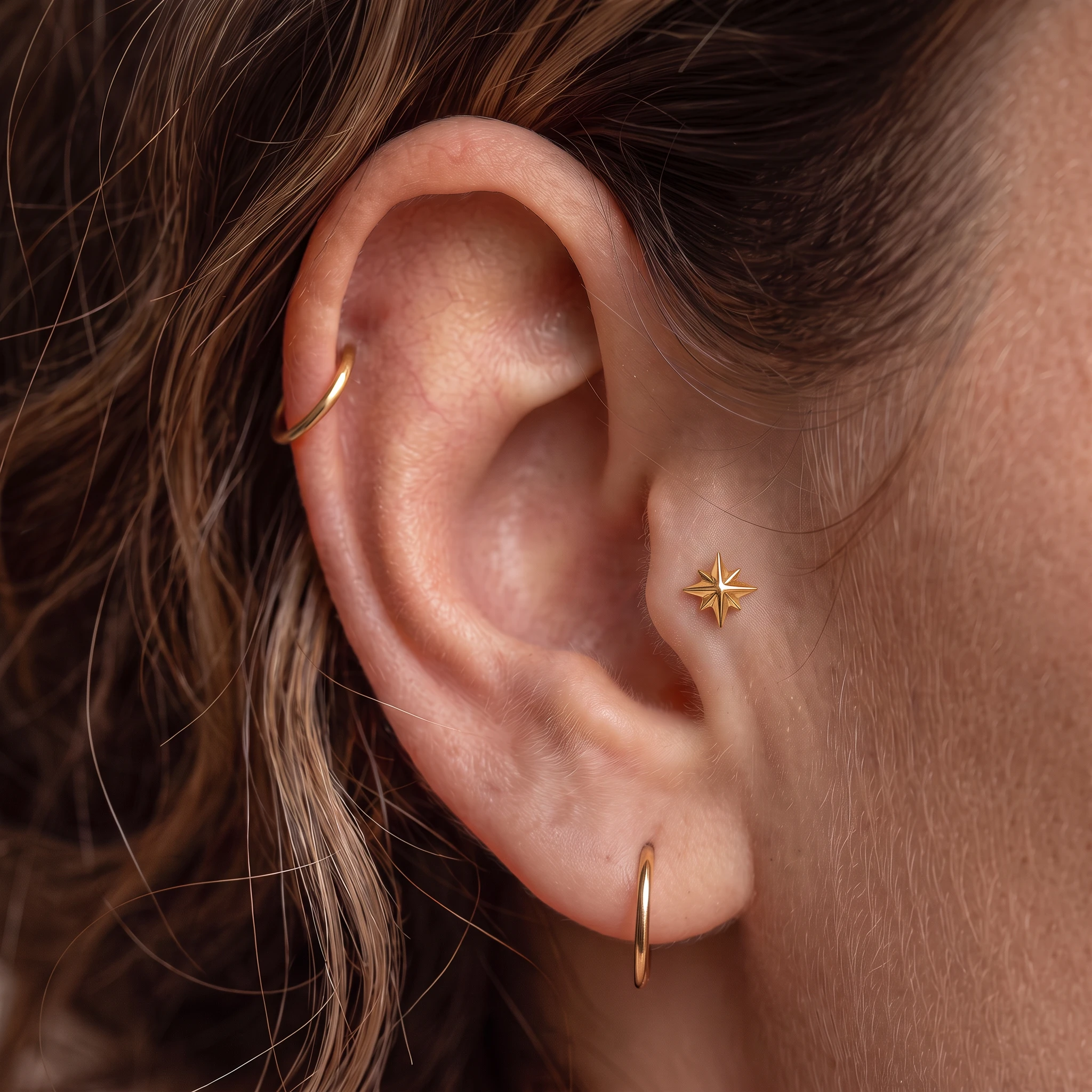 Piercing de tragus en titane doré L'Étoile Montante V2 porté, étoile polaire devant le conduit de l'oreille