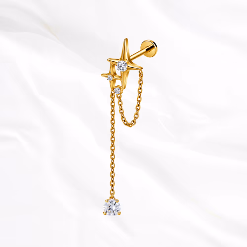 Labret en titane doré La Grande Constellation, étoile sertie et chaînette doublée jusqu’à un zircon poire suspendu