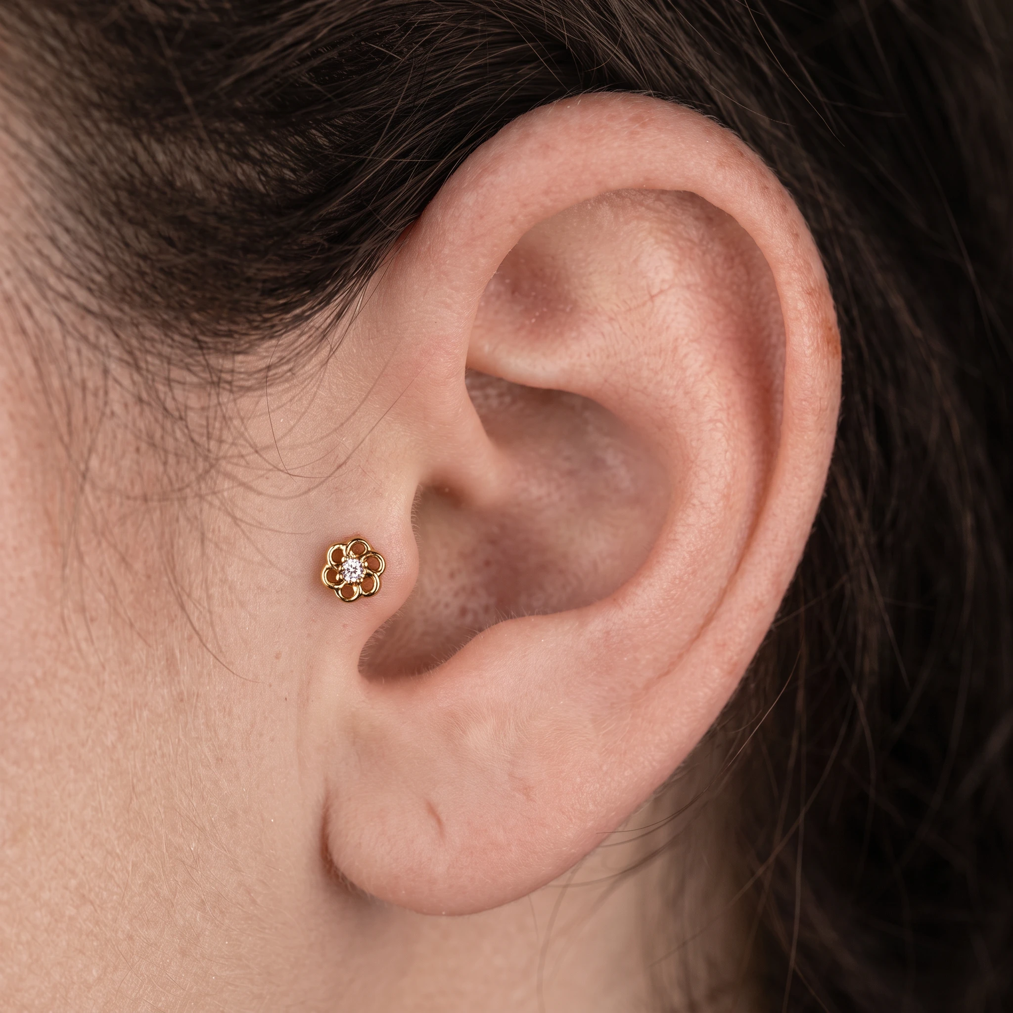 Piercing La Marguerite en titane doré porté à l'oreille