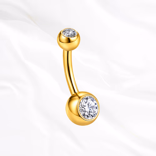 Piercing de nombril banane en titane doré Le Nombriliste, un zircon serti clos à chaque extrémité dans une monture affleurante