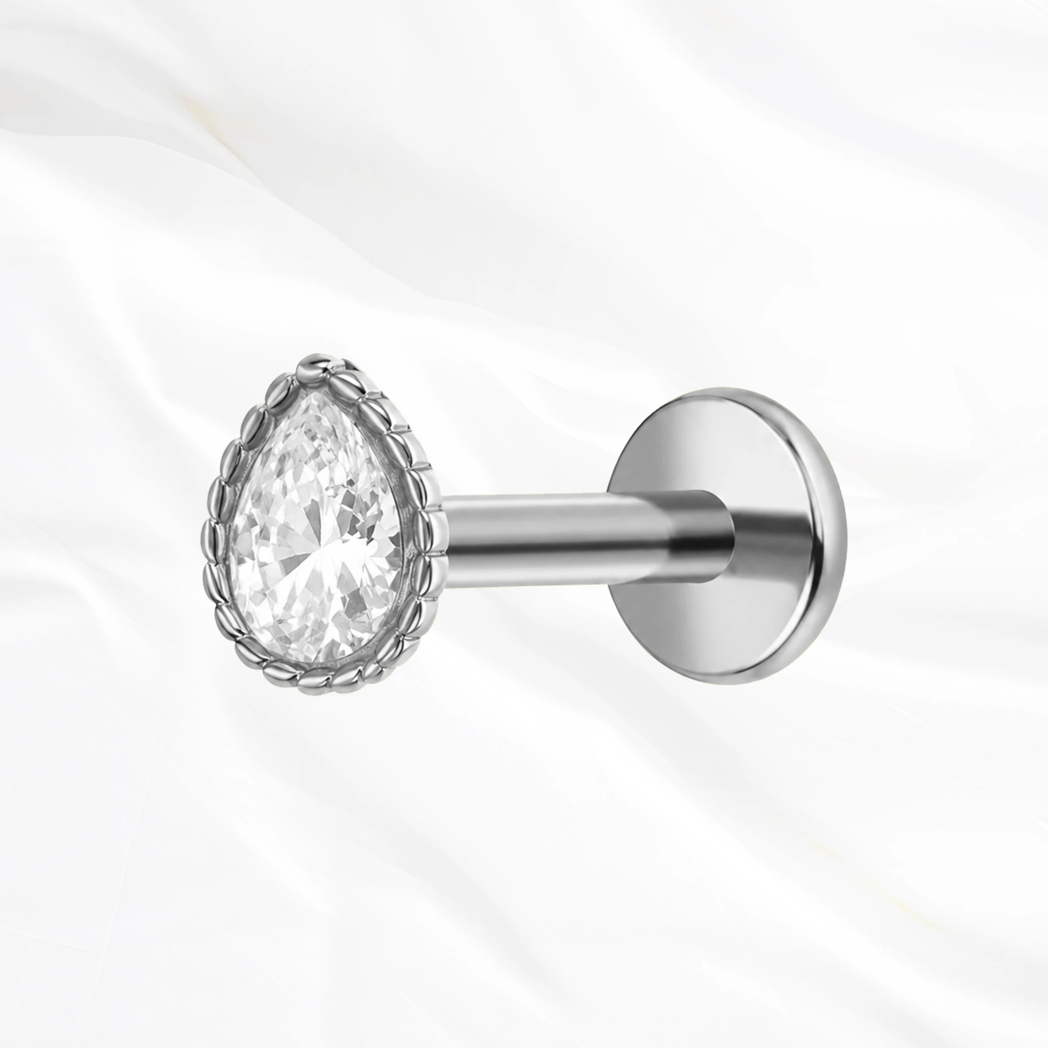 Labret push-in en titane argenté L’Obélisque, zircon taille poire serti clos dans une monture bordée de fines billes