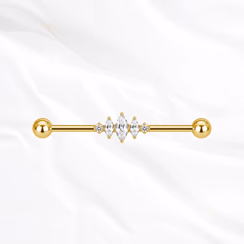 Barre industrielle en titane doré L’Ondulante, un zircon rond, une grande marquise puis un second rond alignés sur la tige