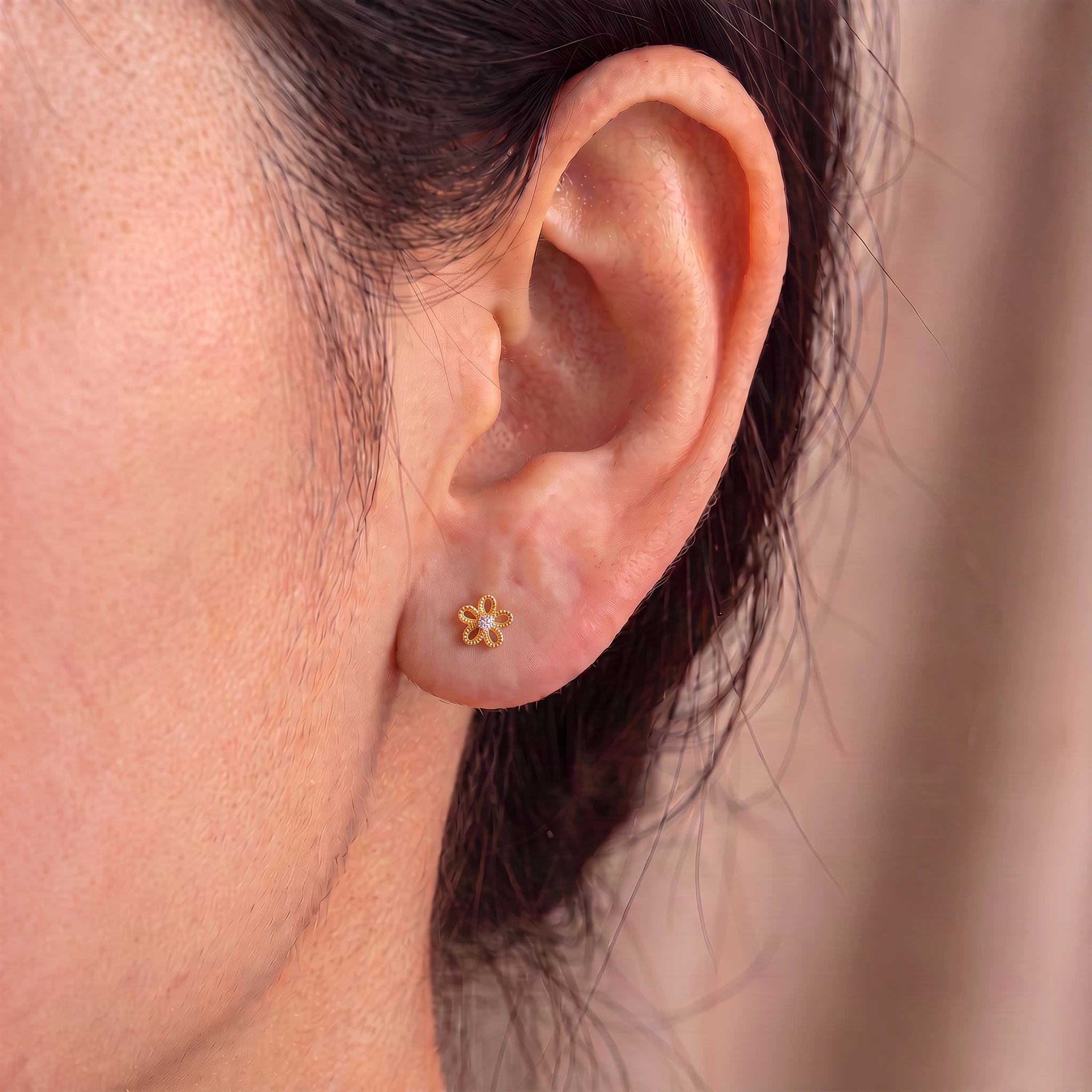 Piercing La Pâquerette en titane doré porté à l'oreille