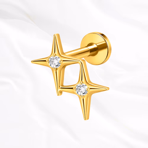 Labret en titane doré La Petite Constellation, deux étoiles à quatre branches serties d’un zircon et reliées par une barre