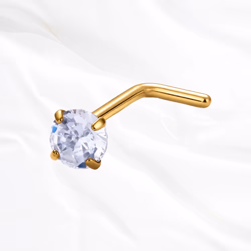 Piercing de nez en titane doré Le Serti, tige coudée en L surmontée d’un zircon tenu par quatre griffes qui le surélèvent