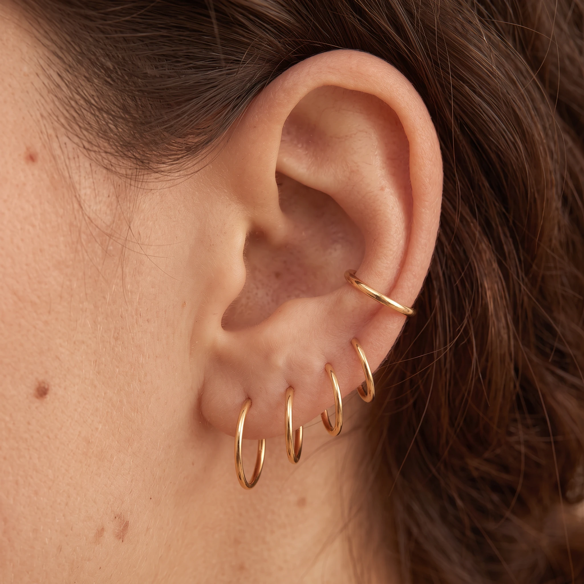 Piercing Le Simple V2 en titane doré porté à l'oreille