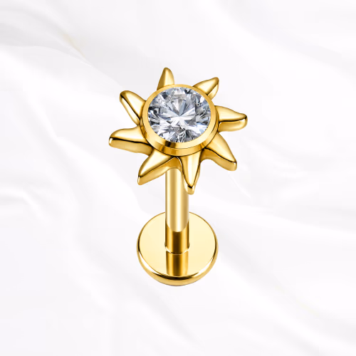 Piercing labret en titane doré motif fleur soleil (sunburst) avec zircon central pour tragus ou conch