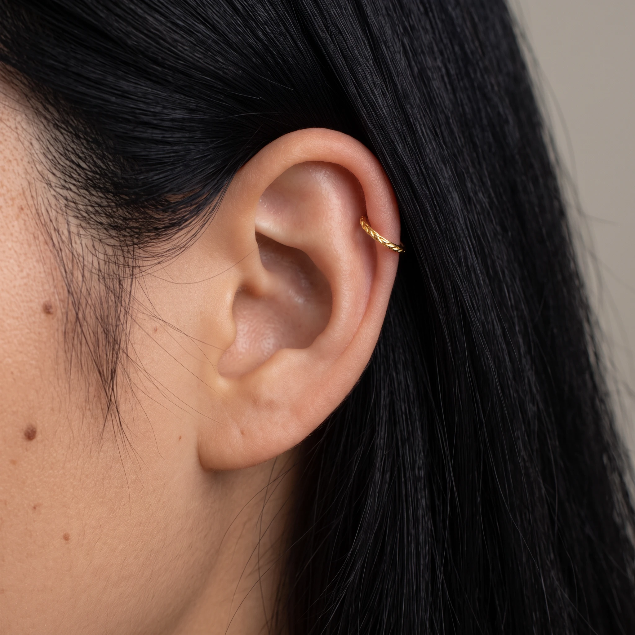 Piercing Le Tressé en titane doré porté à l'oreille