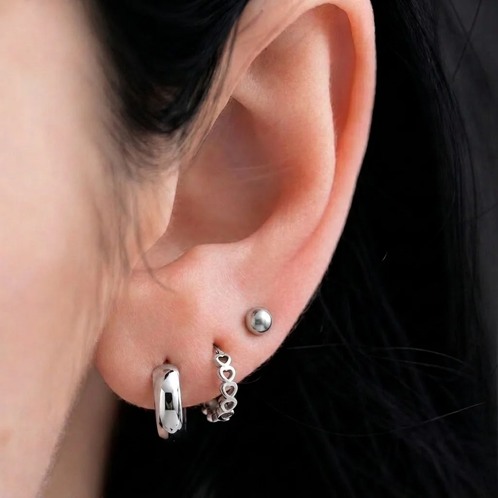 Piercing Le Large Simple en titane argenté porté au lobe de l'oreille, anneau épais à section bombée