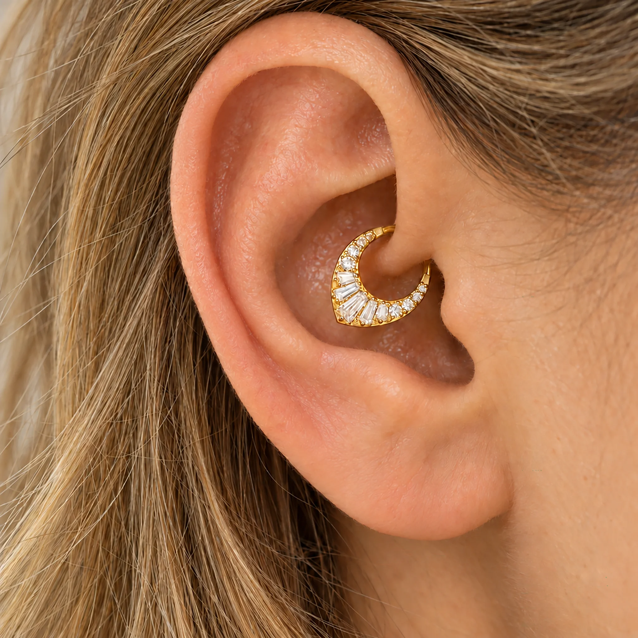Anneau de daith en titane doré Le Chevron Grand Brillant porté dans le pli intérieur de l'oreille, zircons baguette et zircons ronds