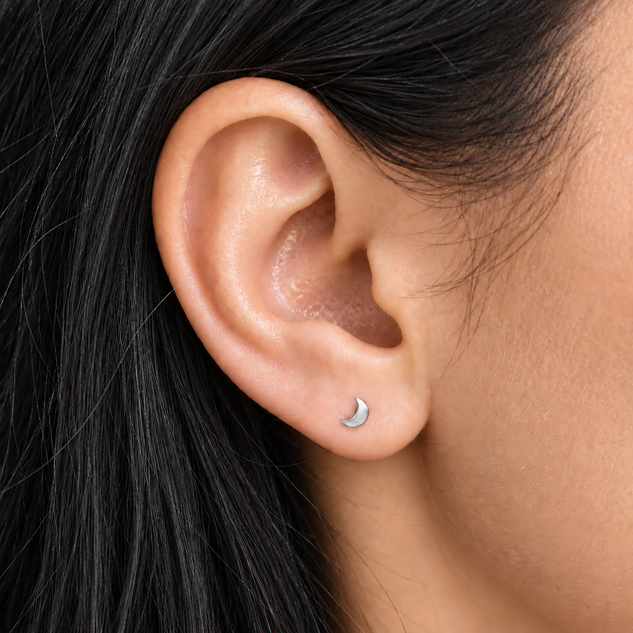 Piercing de lobe en titane argenté La Lune Juvénile porté, petit croissant de lune sur le lobe